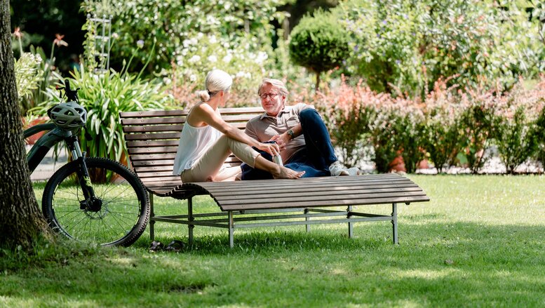 Aktivitäten im Sommerurlaub Bad Füssing, Deutschland Zwei Personen auf einer Parkbank unterhalten sich während ihres Sommerurlaubs in Bad Füssing.